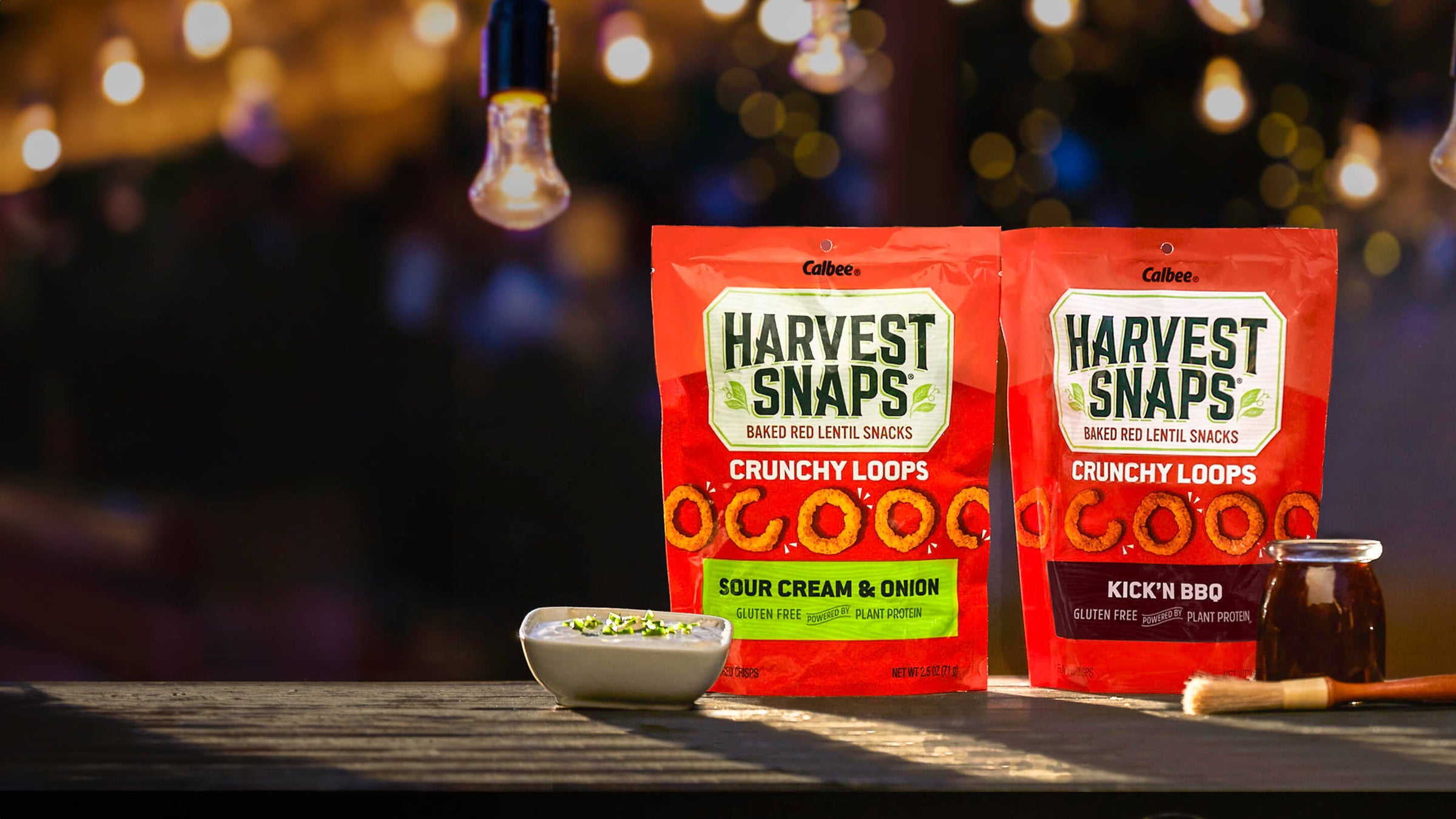 Harvest Snaps Crunchy Loops Sour cream & onion and Kick'N BBQ in backyard theme.
