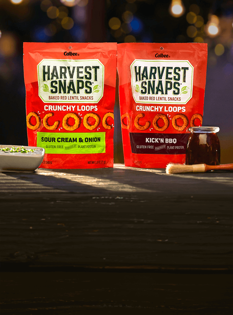 Harvest Snaps Crunchy Loops Sour cream & onion and Kick'N BBQ in backyard theme. 