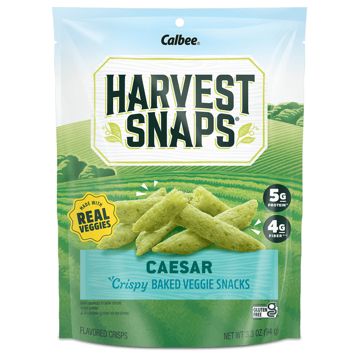 Packaging of Harvest Snaps Caesar baked veggie snacks. Green sticks pictured, claiming 5g protein, 4g fiber, gluten-free, made with real veggies.