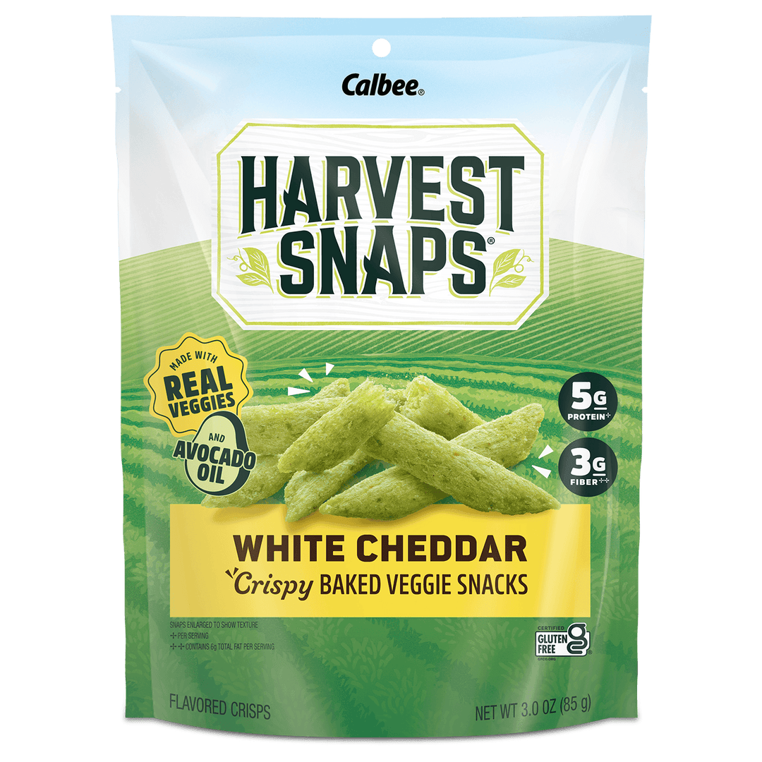 A 3.0 oz bag of Calbee Harvest Snaps White Cheddar Crispy Baked Veggie Snacks, featuring a green and white package design with an illustration of the green chips and product details.