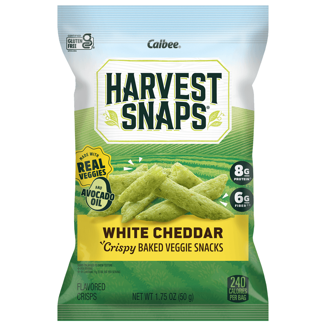 A bag of Calbee Harvest Snaps White Cheddar Crispy Baked Veggie Snacks, featuring green cheese-flavored sticks on the front of the packaging.