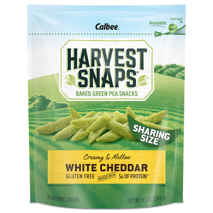 A package of Harvest Snaps snack crisps with White Cheddar flavor. The packaging is predominantly green and white, with an image of the snack crisps on the front.