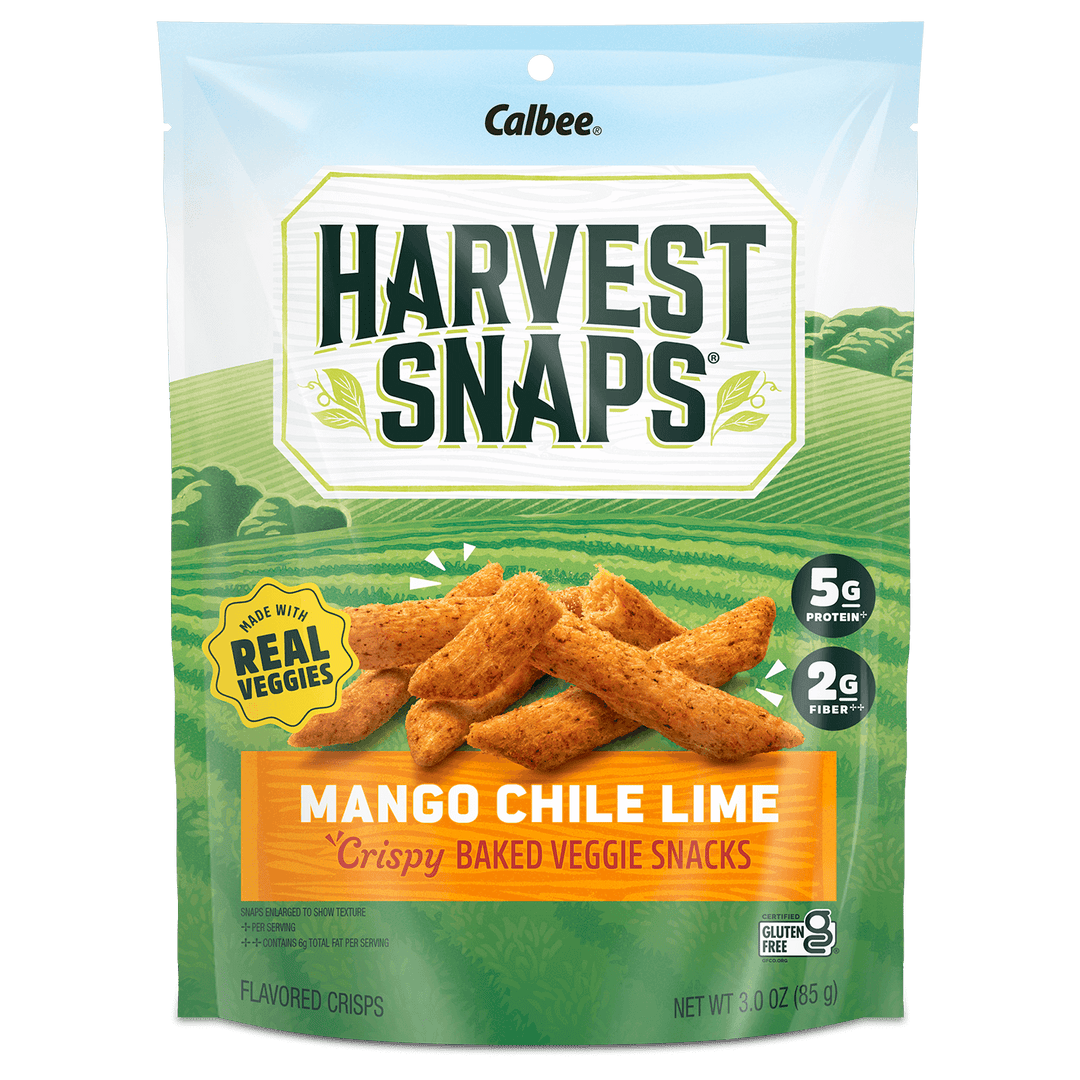 A package of Harvest Snaps Mango Chile Lime crispy baked veggie snacks. The design features a vibrant field background with product benefits like "5g protein" and "2g fiber."