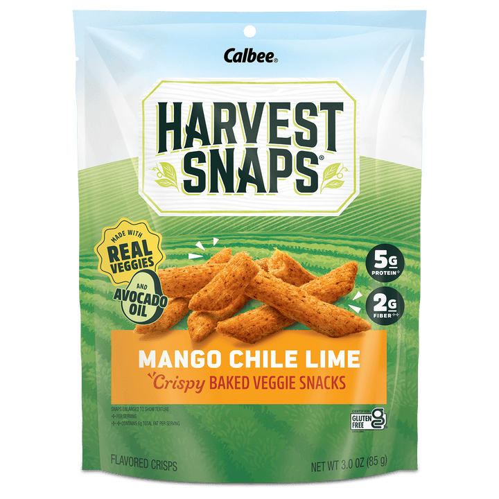 A package of Calbee Harvest Snaps Mango Chile Lime flavored crispy baked veggie snacks. The bag is green and white with an illustration of golden-brown snack sticks, and features badges indicating it is made with real vegetables and avocado oil.